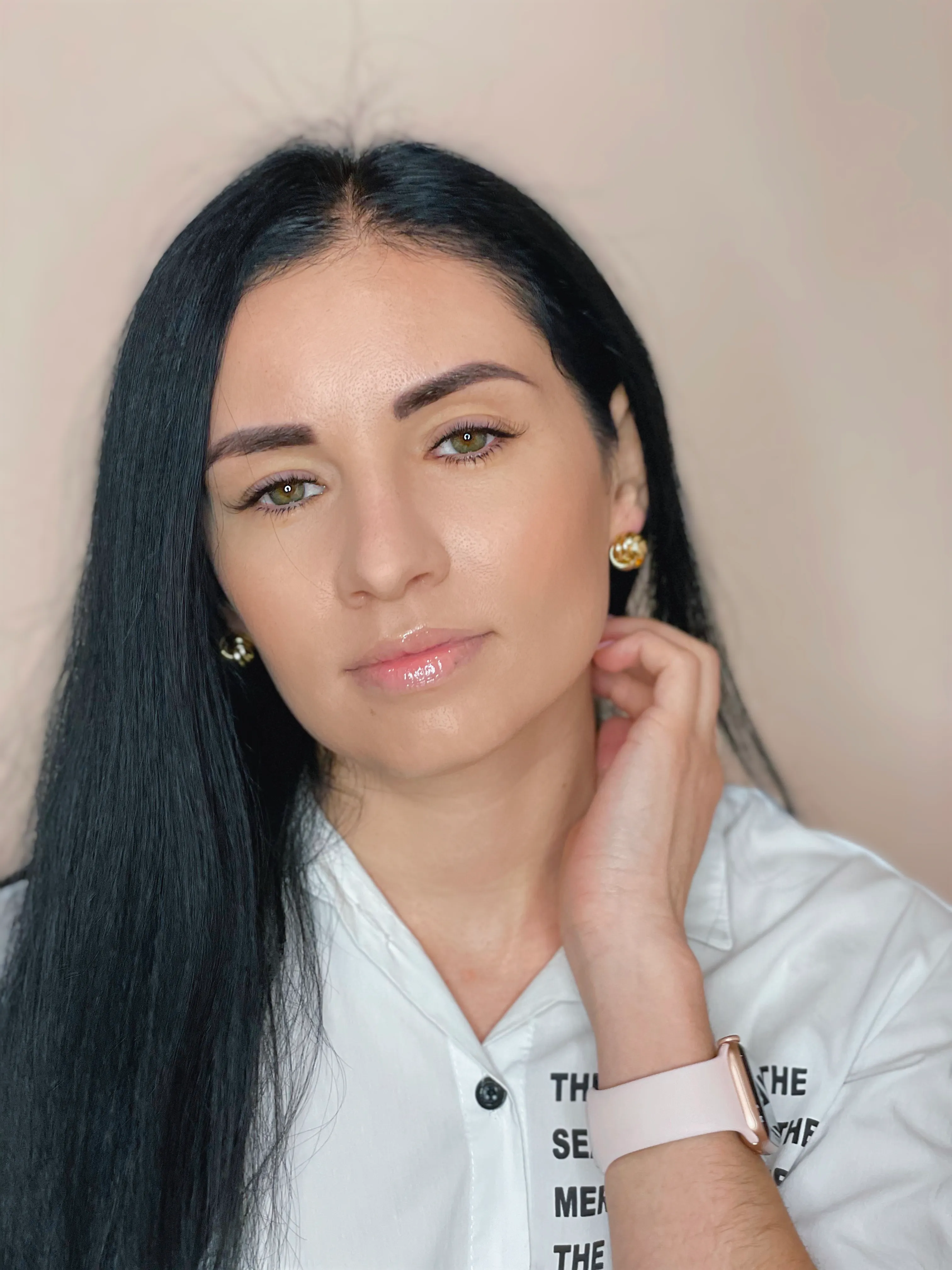 Portrait of a woman with dark hair wearing a white shirt.